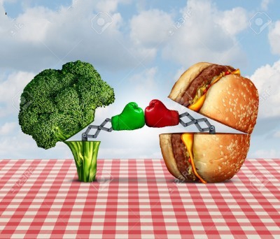 ۳۴۷۹۱۶۷۰-Diet-battle-and-food-fight-nutrition-concept-as-a-fresh-healthy-broccoli-fighting-an-unhealthy-chees-Stock-Photo