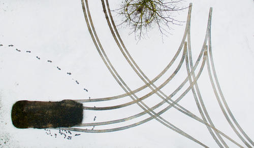 رد پا و تایر و ماشین پارک شده در زمین برفی – آلمان